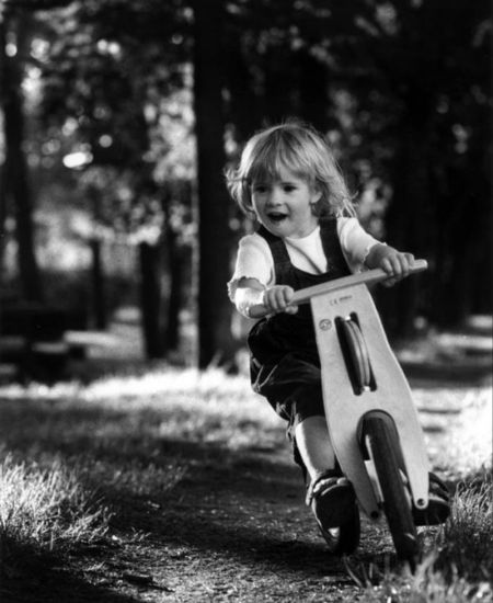 child exploring on balance bike through woods